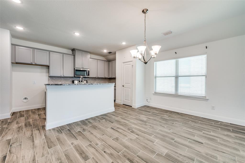 7025 Trailhead Street Little Elm, TX 76227 - Photo 8 of 25 a view of a kitchen with a sink cabinets and wooden floor