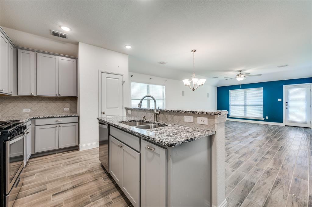 7025 Trailhead Street Little Elm, TX 76227 - Photo 10 of 25 a kitchen with a sink stove and cabinets