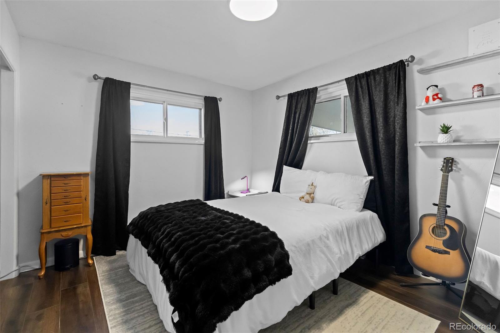 648 South 3rd Avenue Brighton, CO 80601 - Photo 11 of 26 a bedroom with a bed and wooden floor