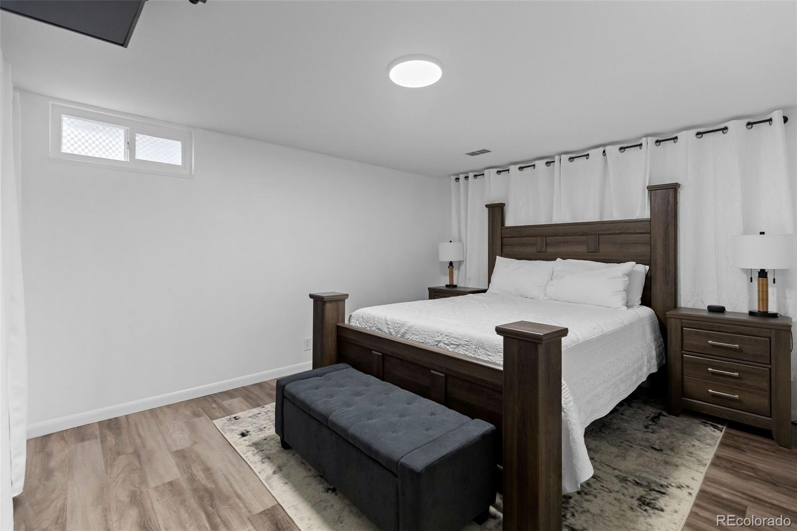 648 South 3rd Avenue Brighton, CO 80601 - Photo 14 of 26 a bedroom with a bed a dresser and a window