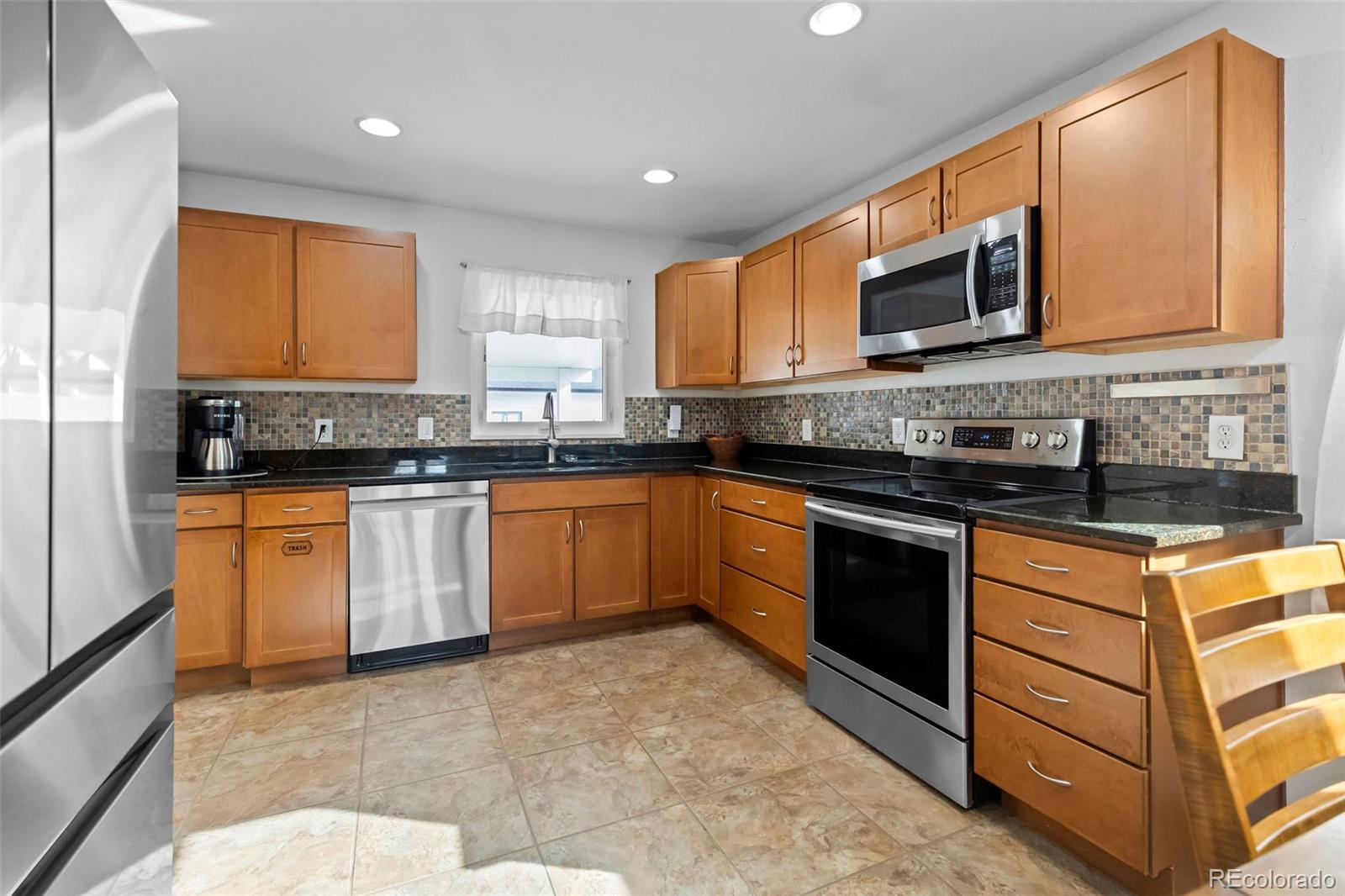 648 South 3rd Avenue Brighton, CO 80601 - Photo 7 of 26 a kitchen with stainless steel appliances granite countertop a stove sink microwave and window