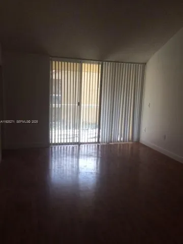 a view of a room with wooden floor and a window