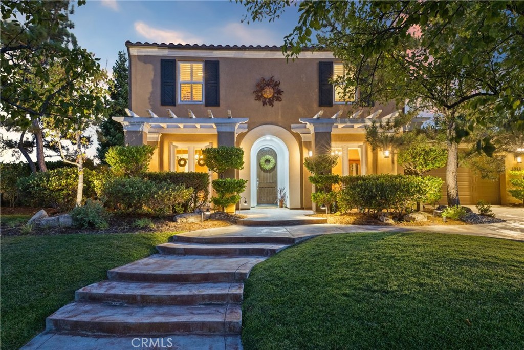 a front view of a house with a garden and plants