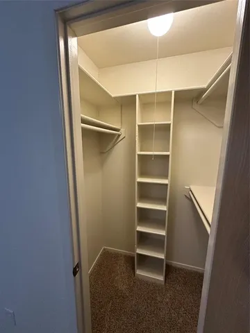 a view of walk in closet with empty racks