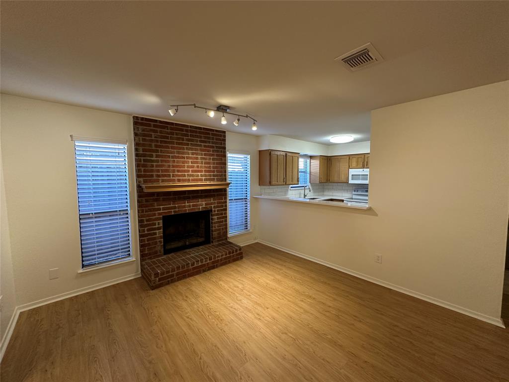 724 Cory Street Grapevine, TX 76051 - Photo 3 of 16 a view of an empty room with wooden floor fireplace and a window