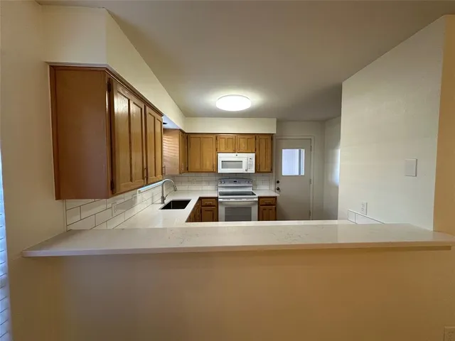 a kitchen with stainless steel appliances a sink a stove and a refrigerator