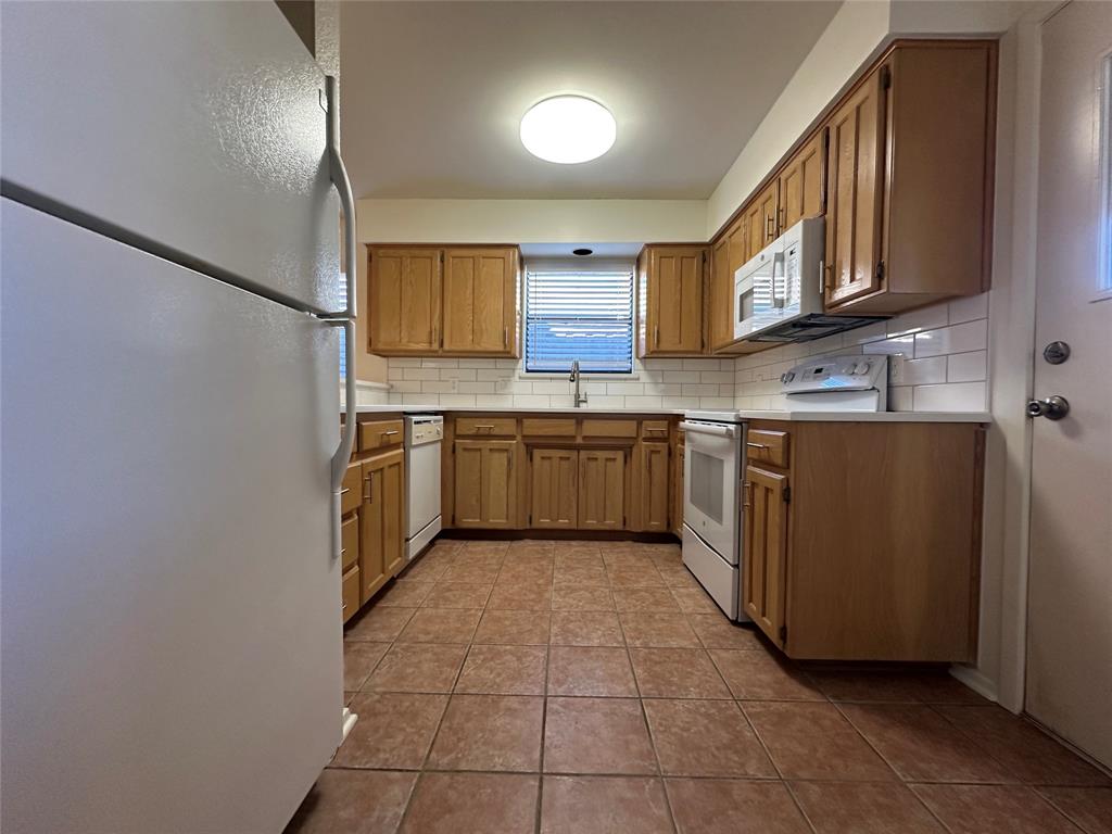 724 Cory Street Grapevine, TX 76051 - Photo 7 of 16 a kitchen with stainless steel appliances granite countertop a sink and cabinets