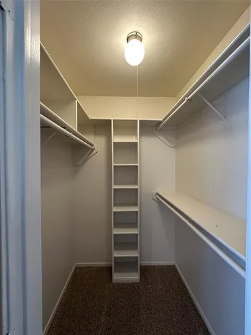 a view of walk in closet with empty racks