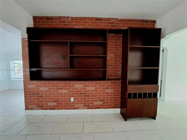 a view of an empty room and kitchen