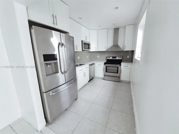 a kitchen with stainless steel appliances granite countertop a refrigerator stove and sink