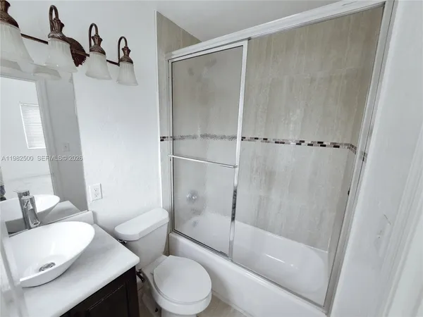 a view of empty room with wooden floor and window