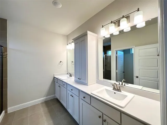a bathroom with a double vanity sink and a mirror