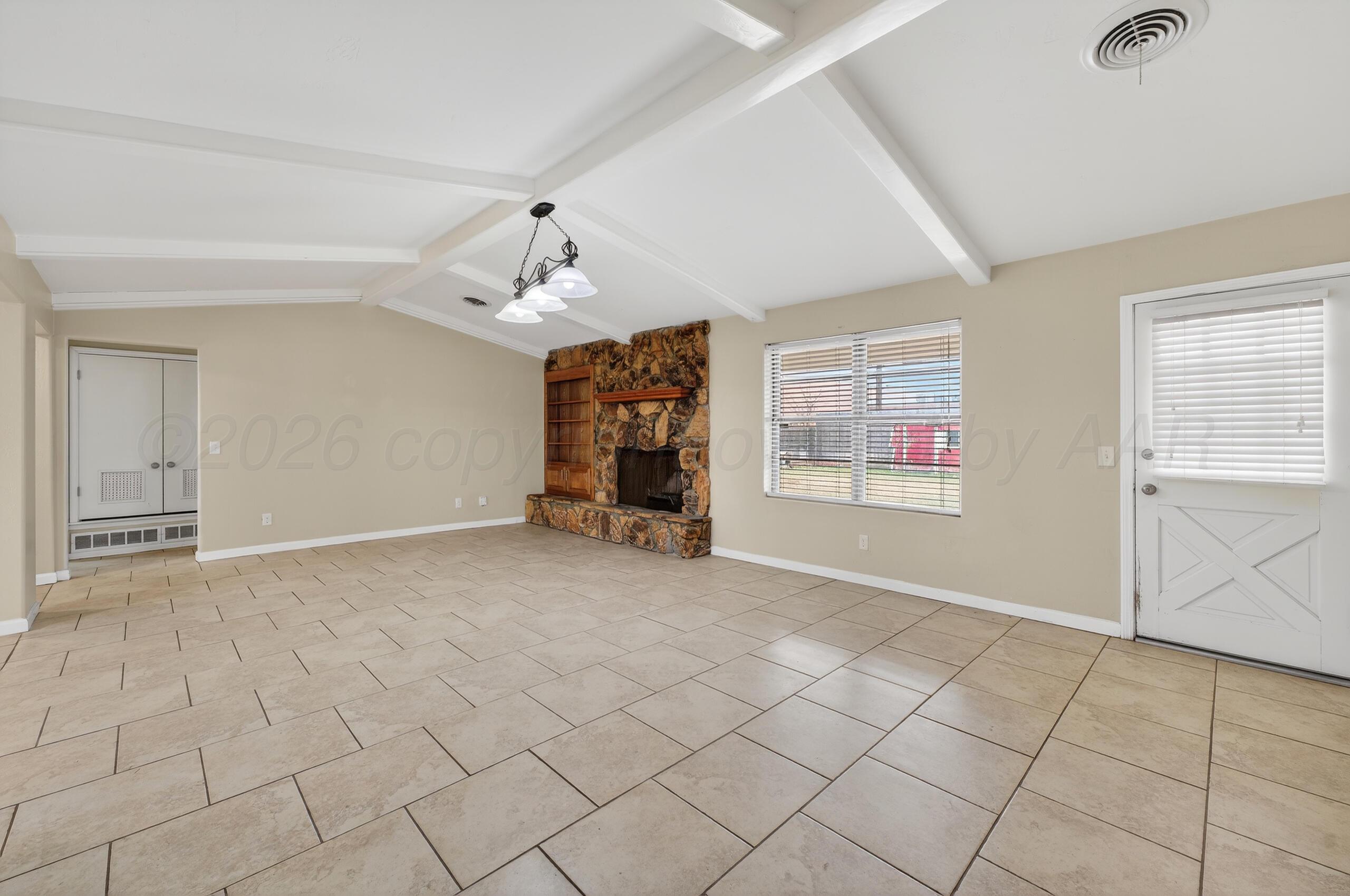 7313 Holyoke Trail Amarillo, TX 79121 - Photo 11 of 56 an empty room with windows and chandelier fan