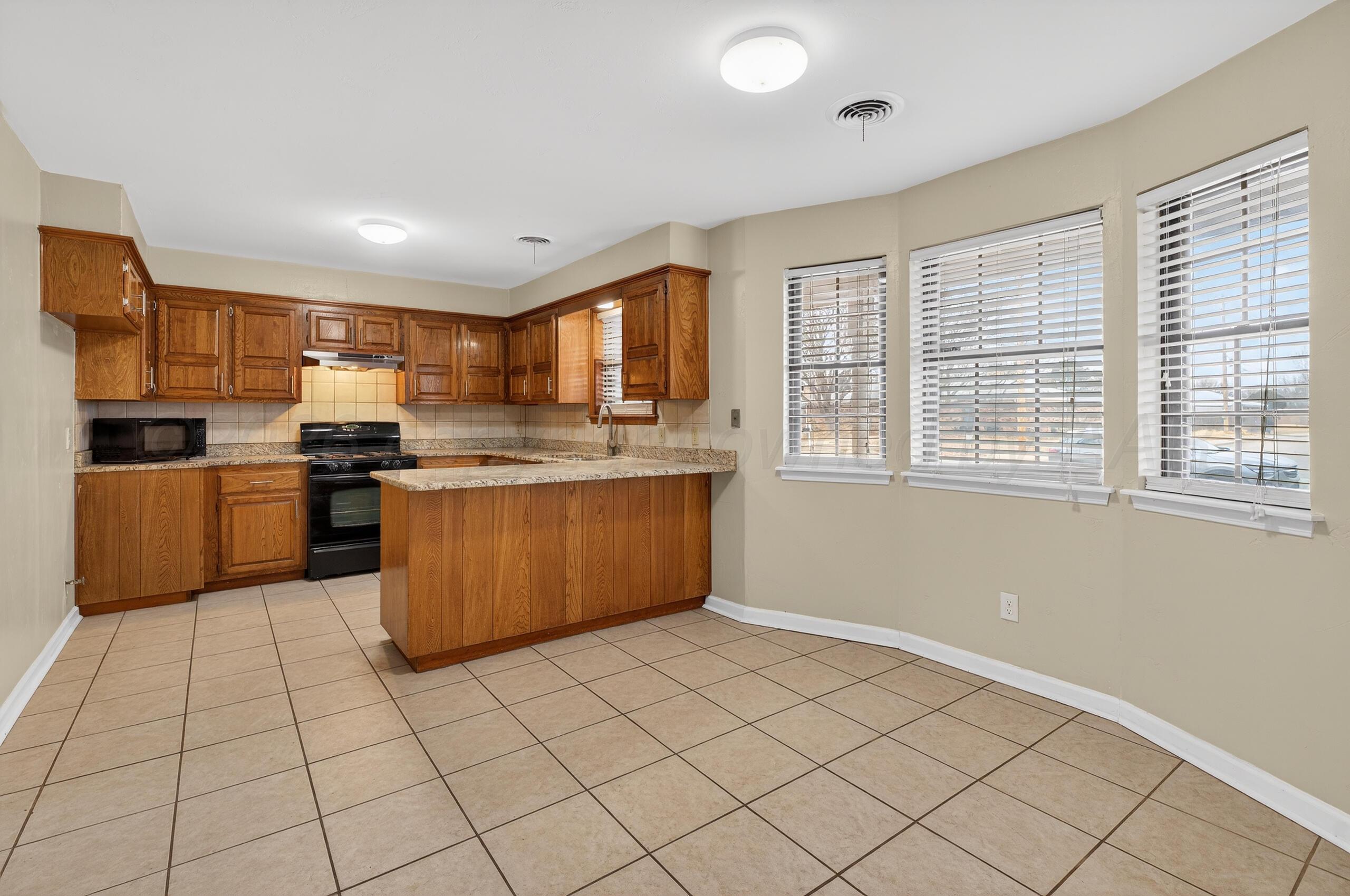 7313 Holyoke Trail Amarillo, TX 79121 - Photo 15 of 56 a kitchen with stainless steel appliances granite countertop a stove top oven a sink a counter top space and cabinets
