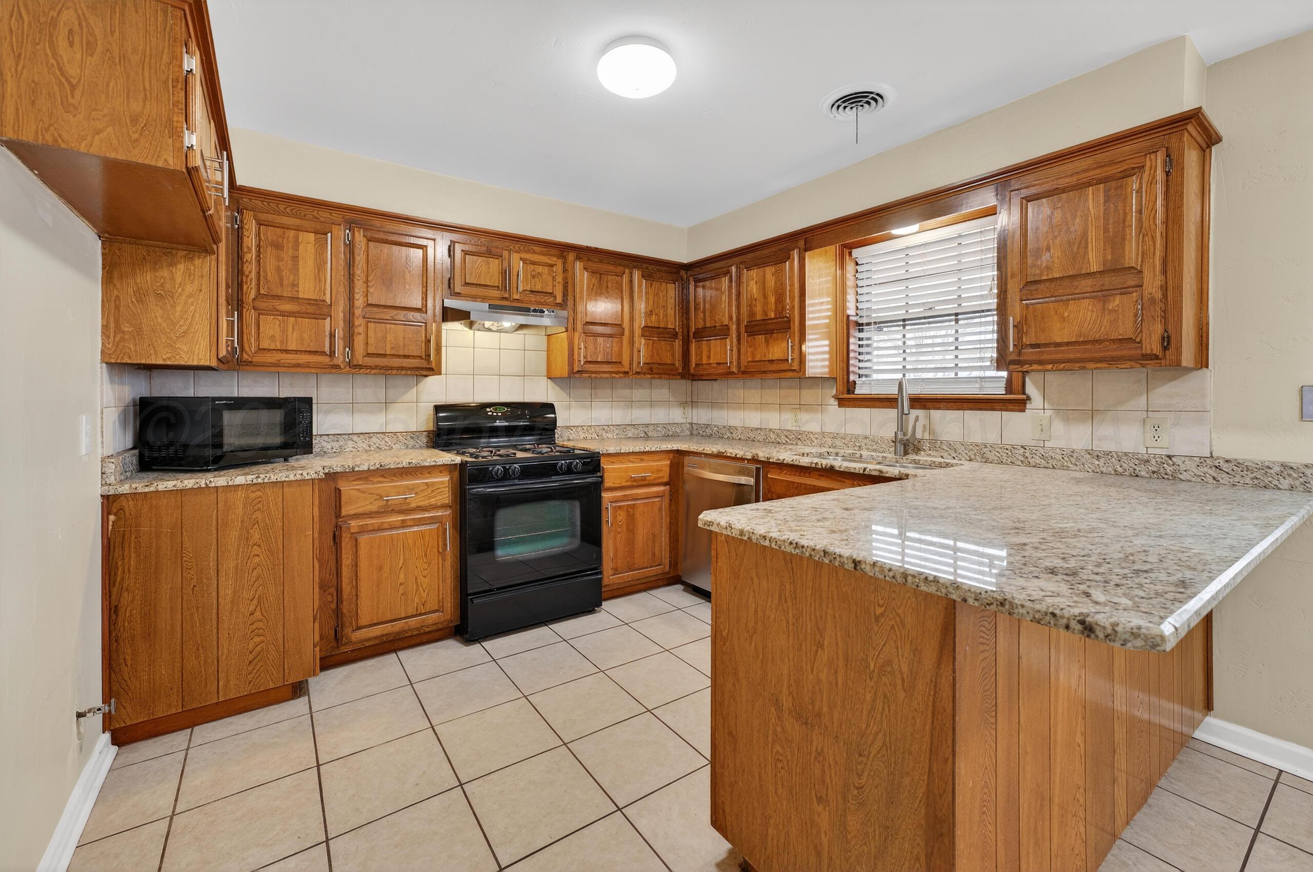 7313 Holyoke Trail Amarillo, TX 79121 - Photo 17 of 56 a kitchen with a sink stove and cabinets