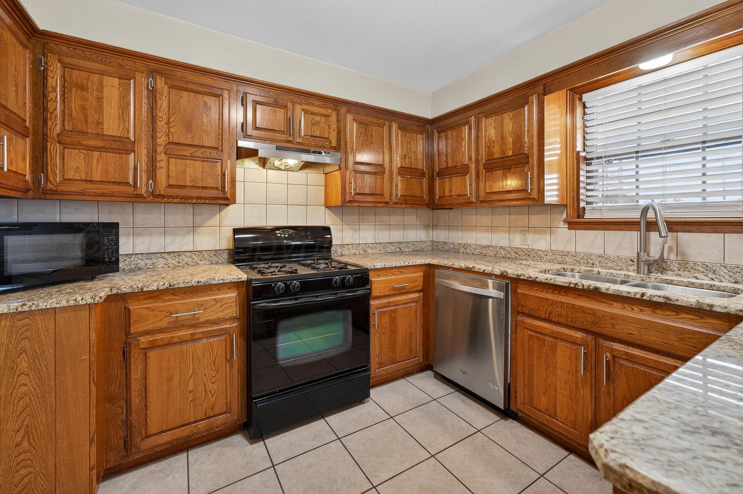 7313 Holyoke Trail Amarillo, TX 79121 - Photo 21 of 56 a kitchen with stainless steel appliances granite countertop a stove sink and cabinets