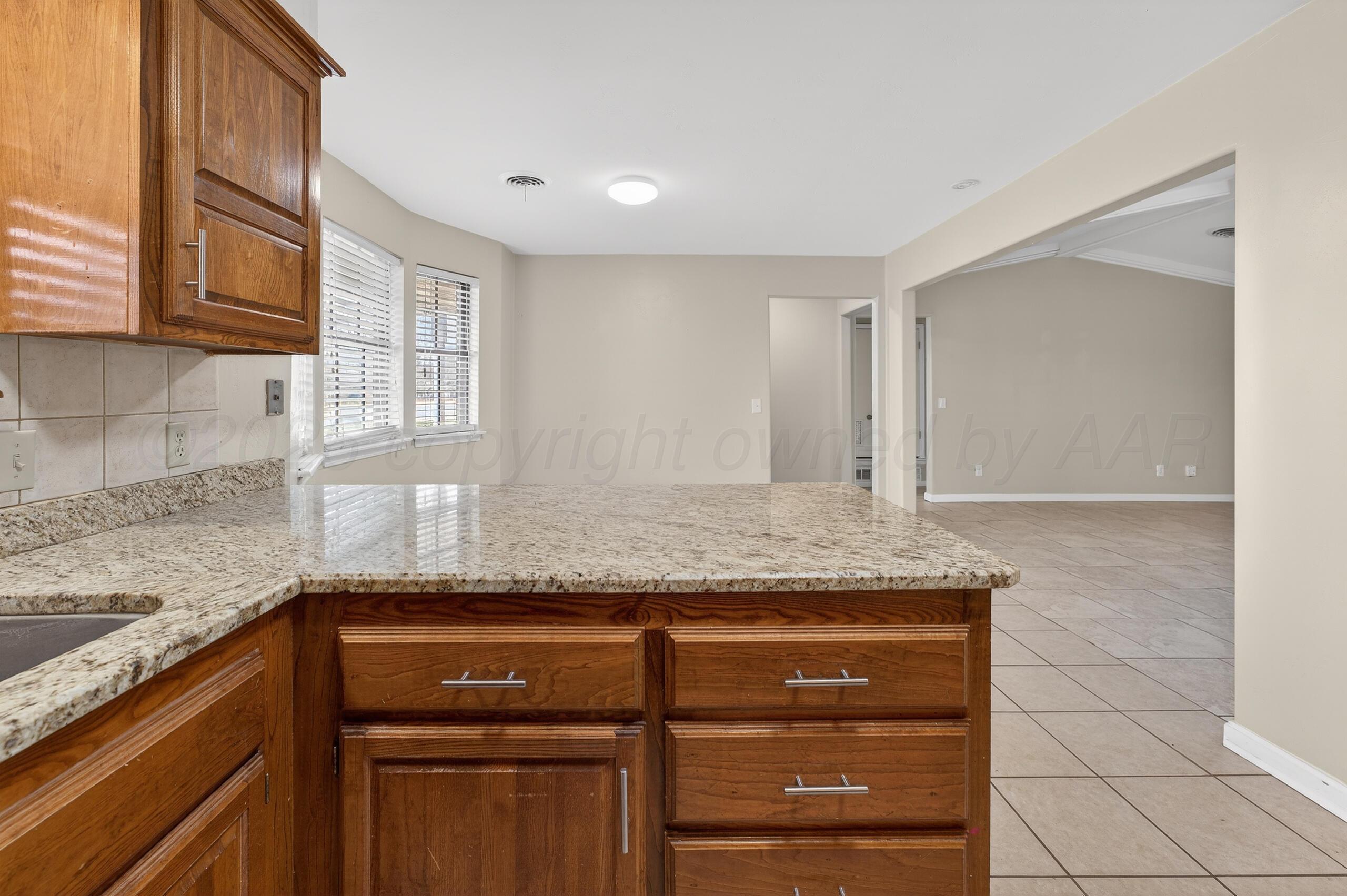 7313 Holyoke Trail Amarillo, TX 79121 - Photo 22 of 56 a kitchen with granite countertop a sink and a stove