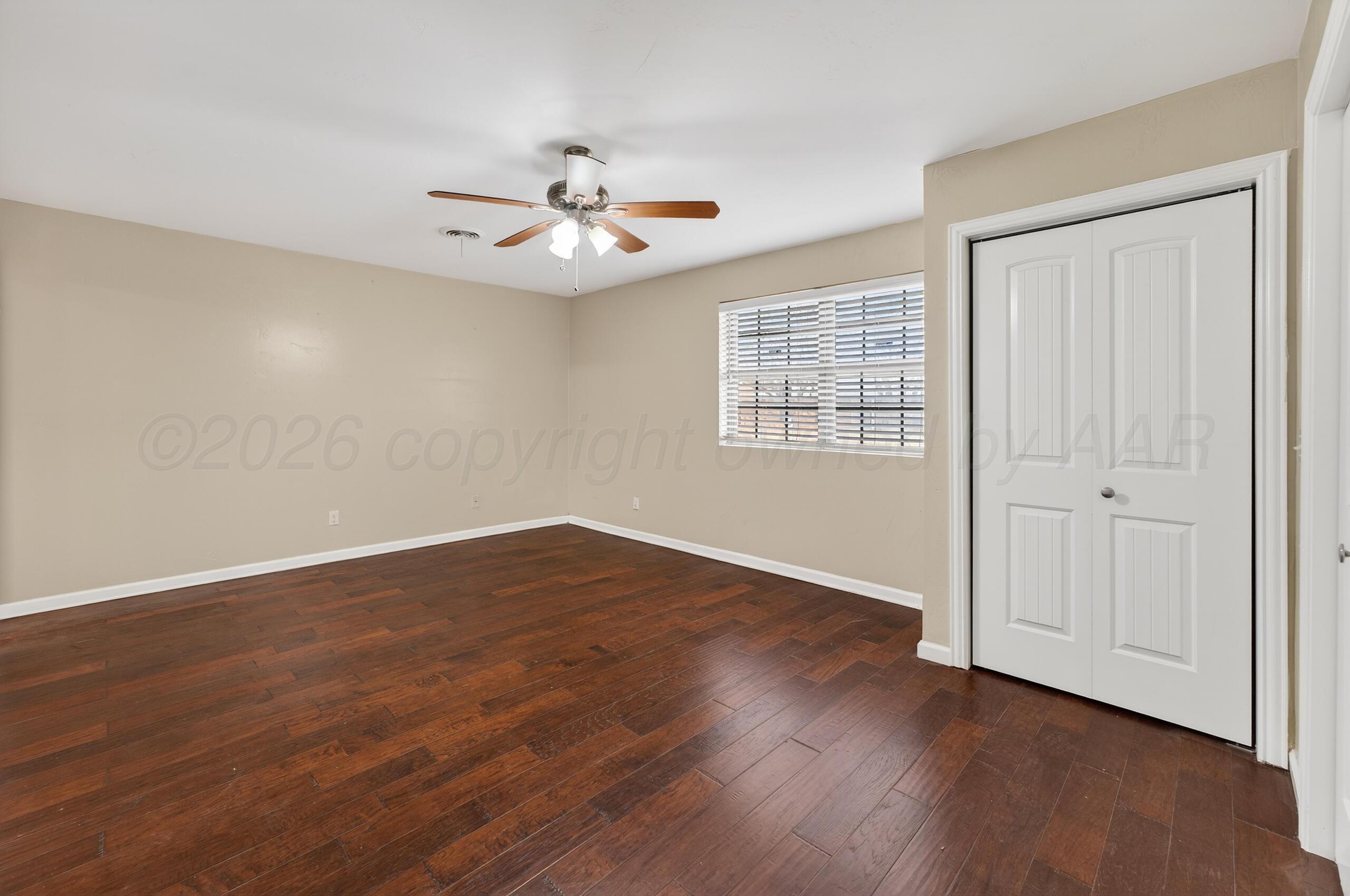 7313 Holyoke Trail Amarillo, TX 79121 - Photo 26 of 56 a view of an empty room with wooden floor and a window