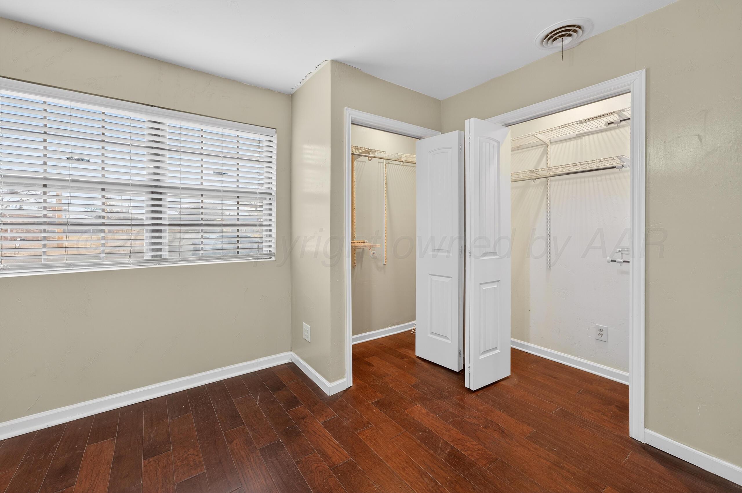 7313 Holyoke Trail Amarillo, TX 79121 - Photo 29 of 56 an empty room with wooden floor and a window