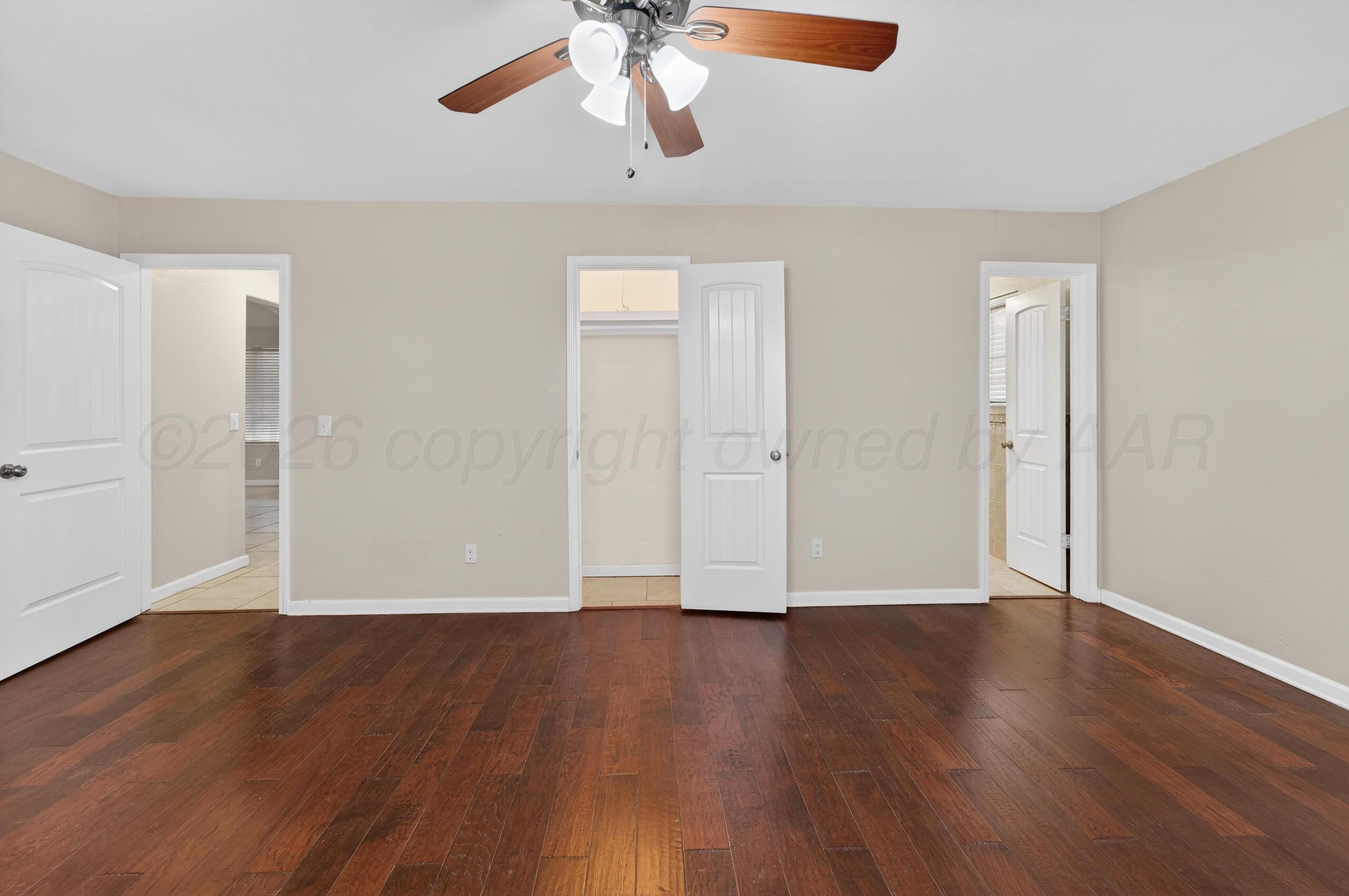 7313 Holyoke Trail Amarillo, TX 79121 - Photo 30 of 56 an empty room with wooden floor chandelier fan and windows