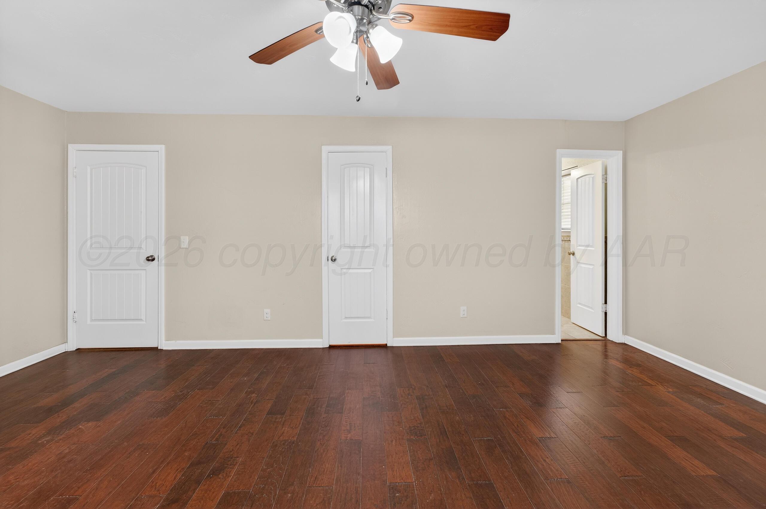 7313 Holyoke Trail Amarillo, TX 79121 - Photo 32 of 56 a view of an empty room with wooden floor and a ceiling fan