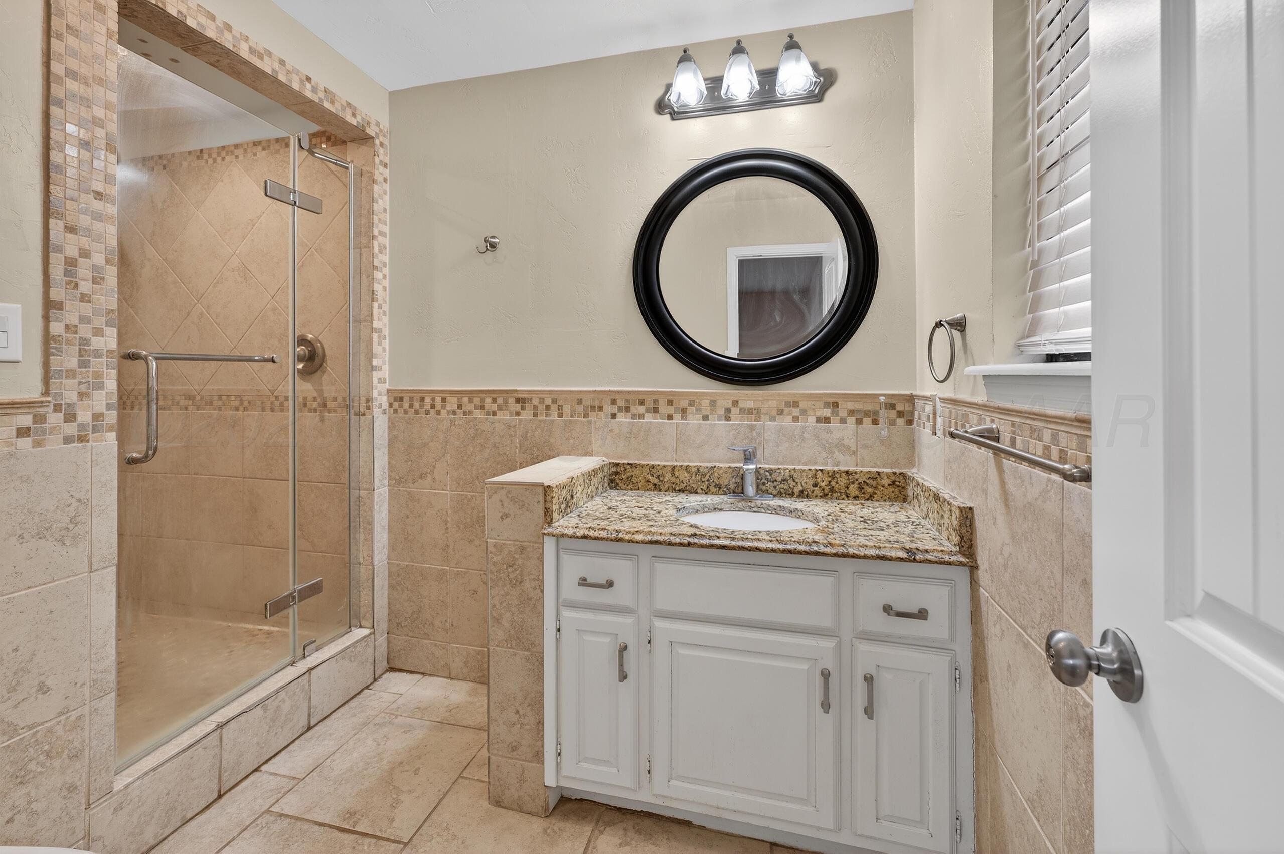 7313 Holyoke Trail Amarillo, TX 79121 - Photo 33 of 56 a bathroom with a granite countertop double vanity sink and a mirror