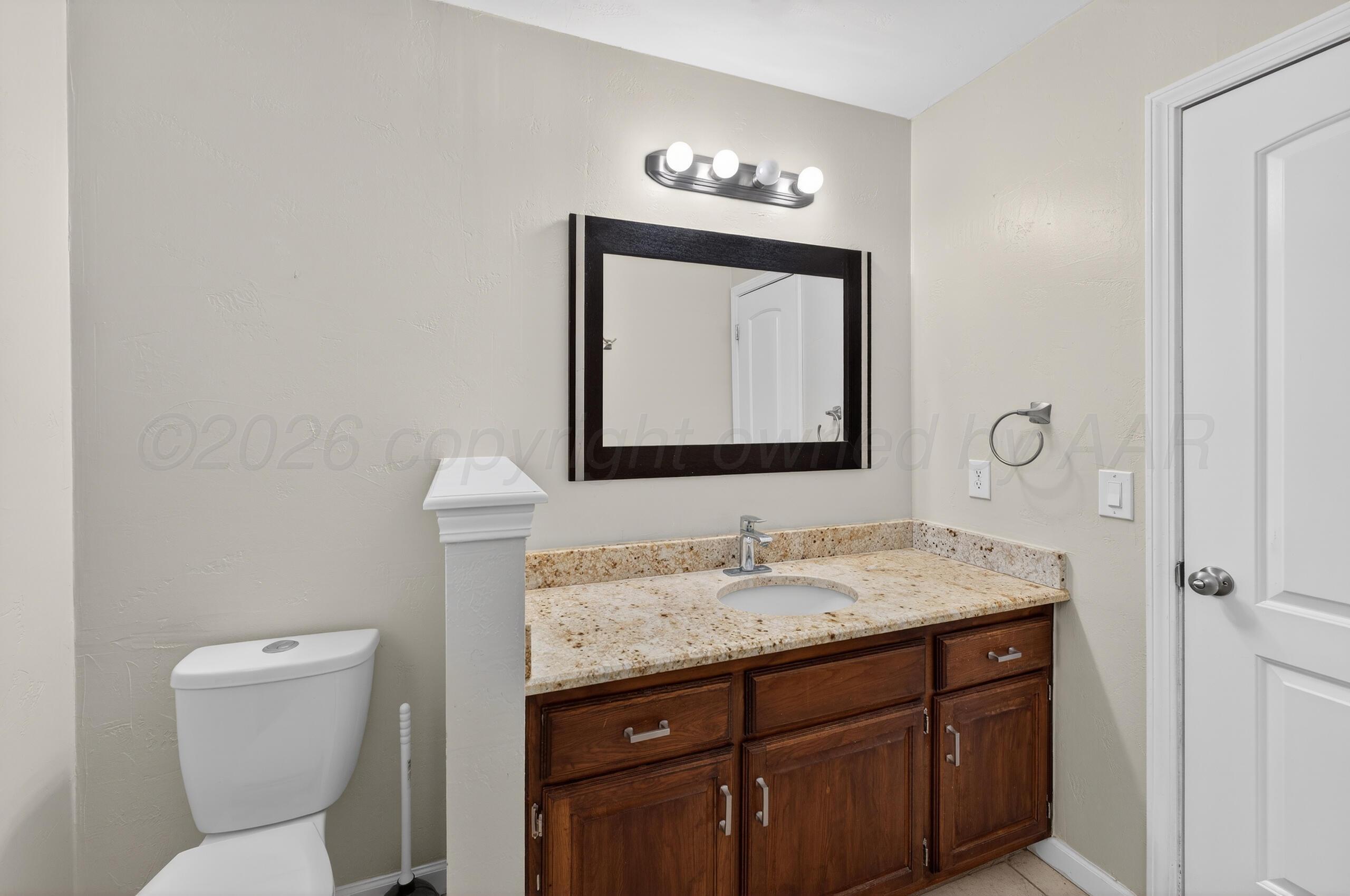 7313 Holyoke Trail Amarillo, TX 79121 - Photo 46 of 56 a bathroom with a toilet sink and mirror