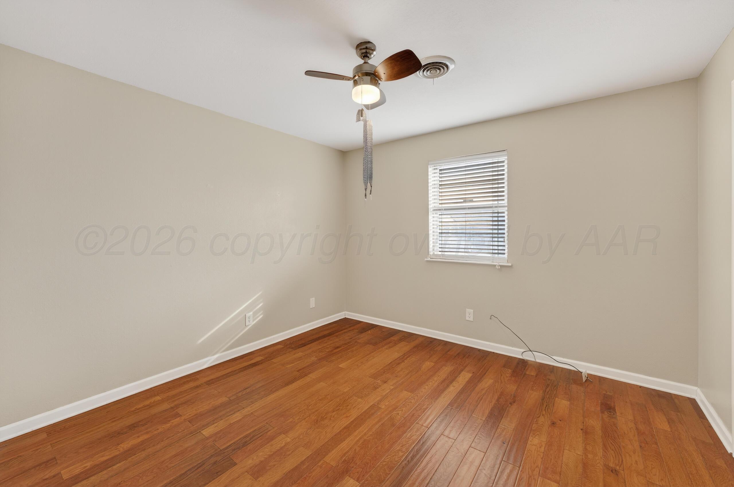 7313 Holyoke Trail Amarillo, TX 79121 - Photo 48 of 56 a view of an empty room with a window and wooden floor