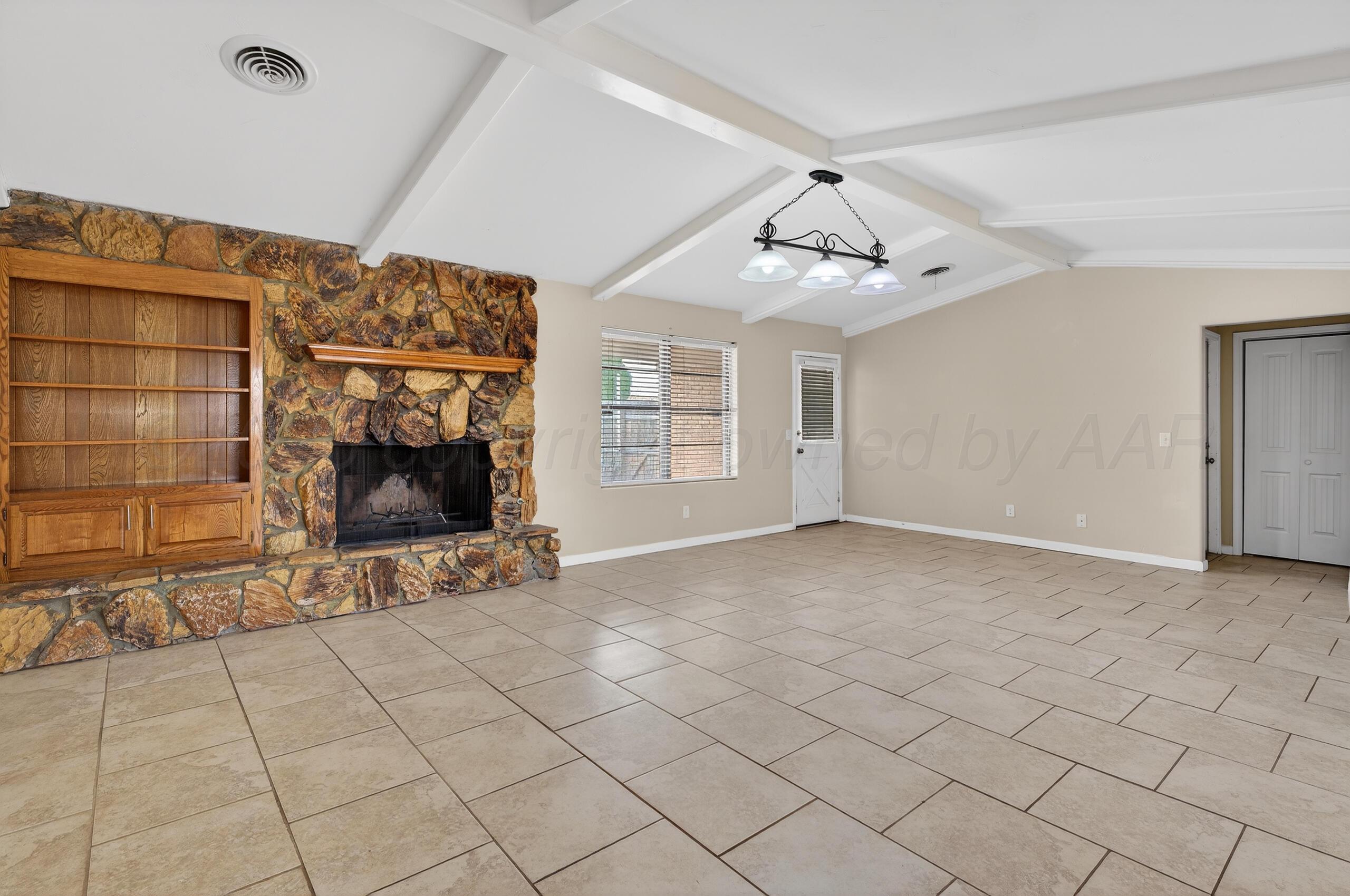 7313 Holyoke Trail Amarillo, TX 79121 - Photo 6 of 56 an empty room with windows and fireplace