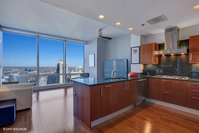 a kitchen with stainless steel appliances granite countertop a sink a stove and a refrigerator