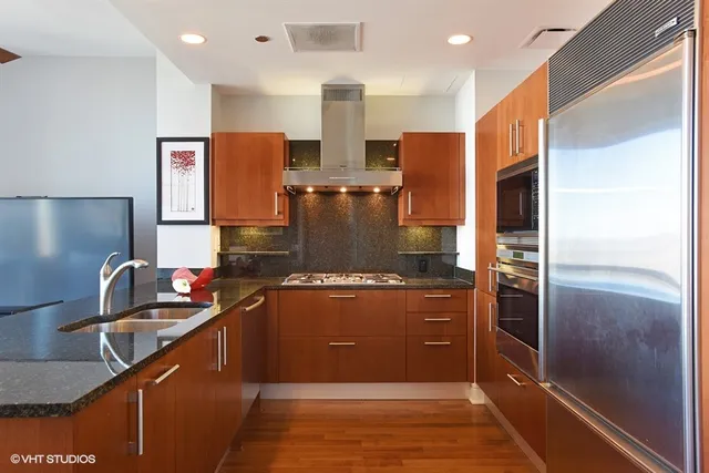 a kitchen with stainless steel appliances granite countertop a refrigerator and a stove
