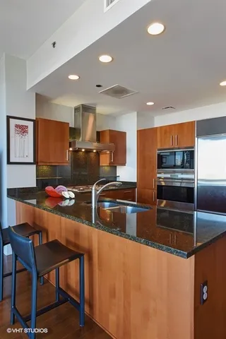 a kitchen with stainless steel appliances kitchen island granite countertop a sink and cabinets