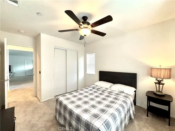 a bedroom with a bed and a ceiling fan