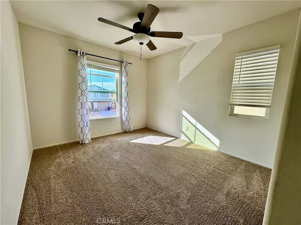 a view of a livingroom with a ceiling fan and window