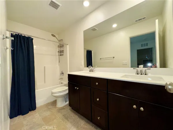 a bathroom with a double vanity sink toilet and shower