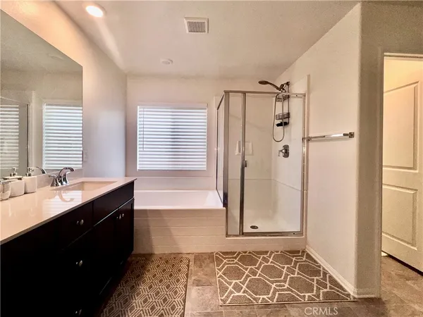 a bathroom with a double vanity sink mirror and a bathtub
