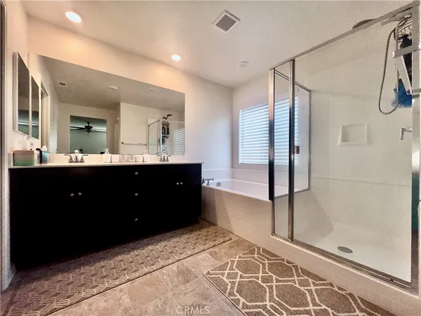 a spacious bathroom with a double vanity sink toilet mirror and bathtub