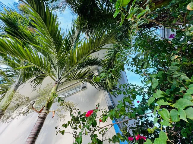a hallway with potted plants in front of door