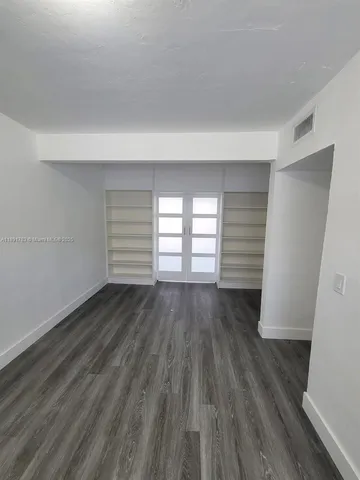 a kitchen with a refrigerator and white cabinets