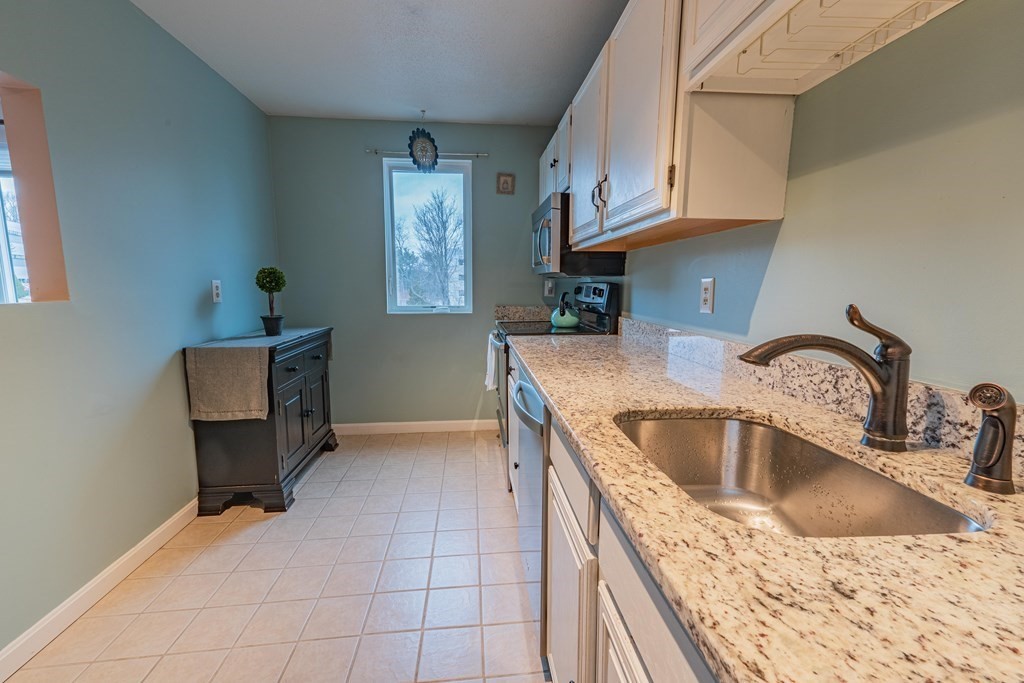 38 Dunham Road, Unit 210 Beverly, MA 01915 - Photo 12 of 30 a kitchen with a sink cabinets and window