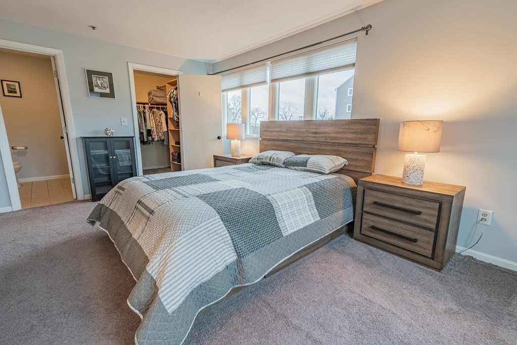 38 Dunham Road, Unit 210 Beverly, MA 01915 - Photo 16 of 30 a bedroom with a bed and wooden floor