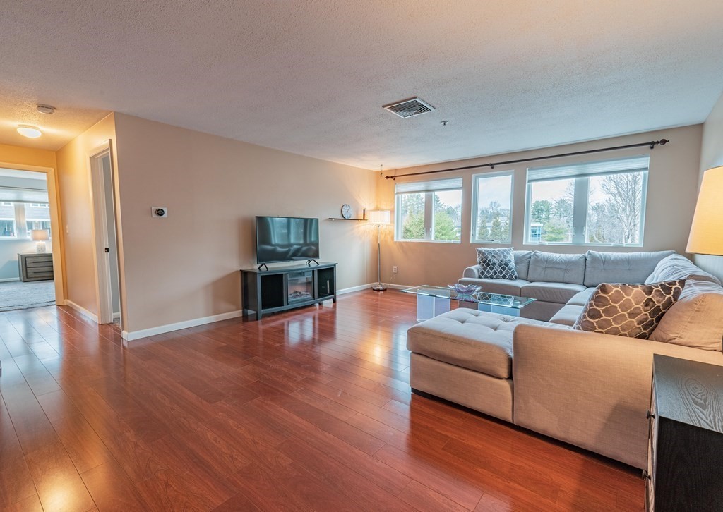 38 Dunham Road, Unit 210 Beverly, MA 01915 - Photo 4 of 30 a living room with furniture and wooden floor
