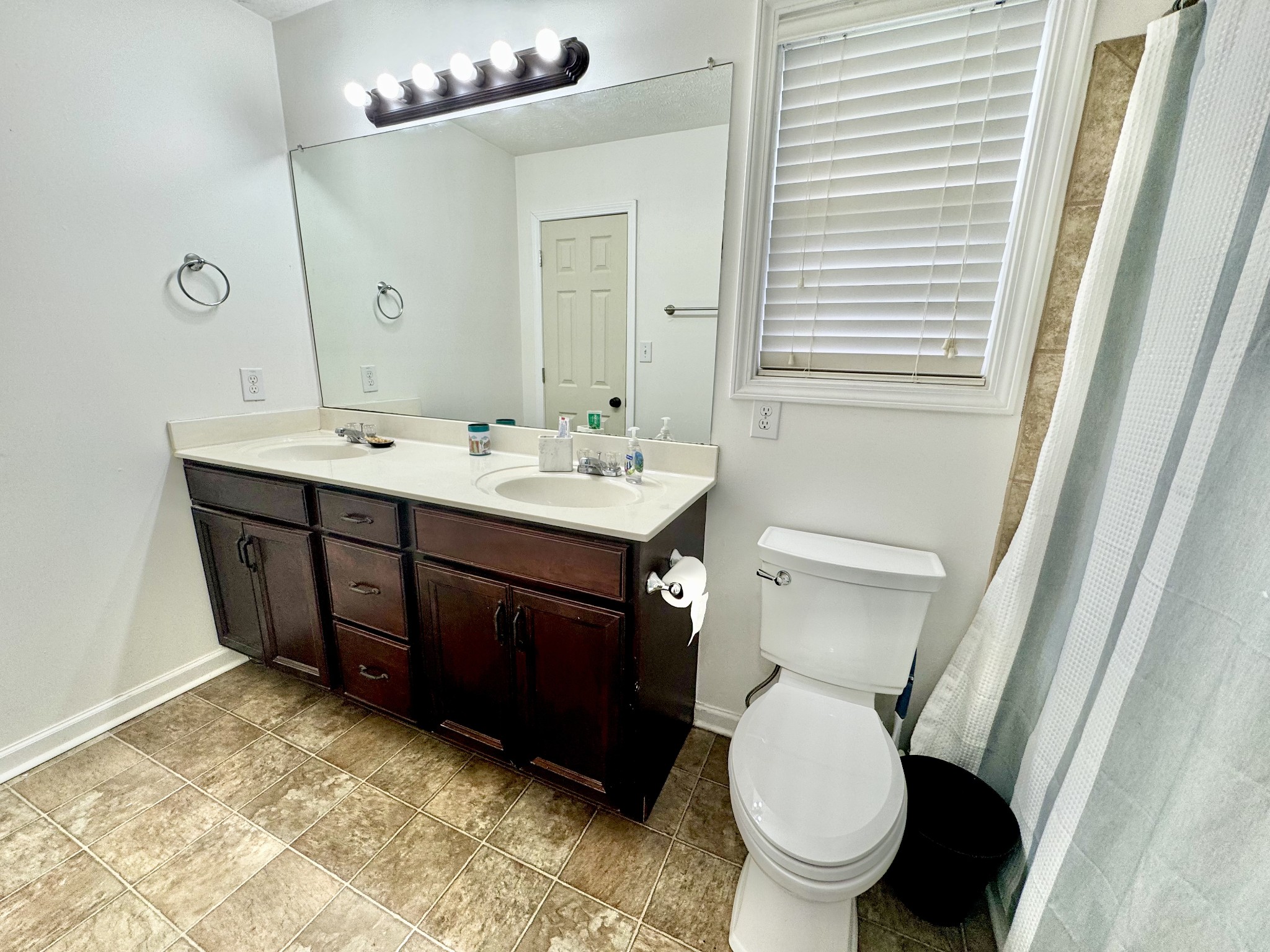 3769 Suiter Road Clarksville, TN 37040 - Photo 5 of 10 a bathroom with a toilet a sink a mirror a vanity and window