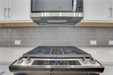 a stove top oven sitting inside of a kitchen