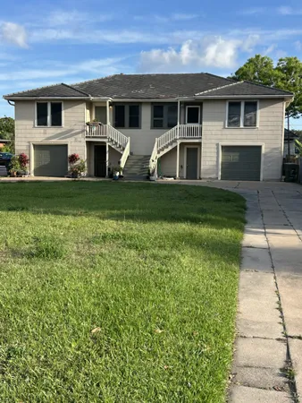 a front view of a house with a garden and yard