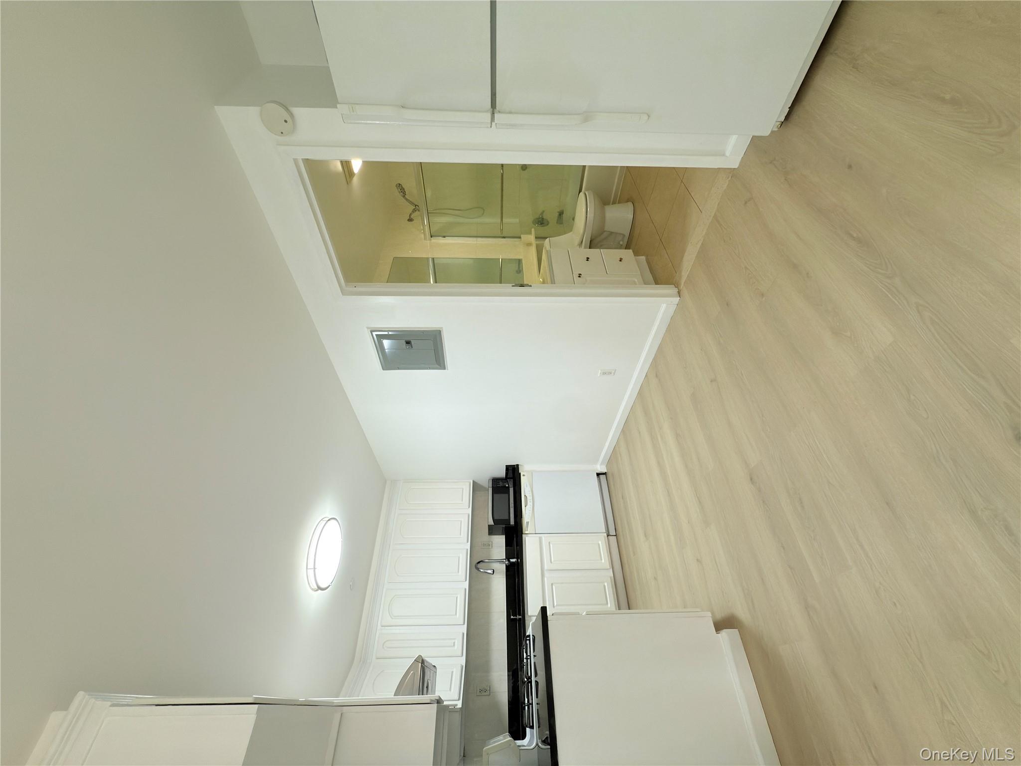 43-17 Union Street, Unit 8B Queens, NY 11355 - Photo 11 of 16 Kitchen featuring fridge, dark countertops, white cabinets, light wood-style floors, and stove