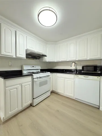 a kitchen with stainless steel appliances granite countertop a sink a stove a microwave and cabinets