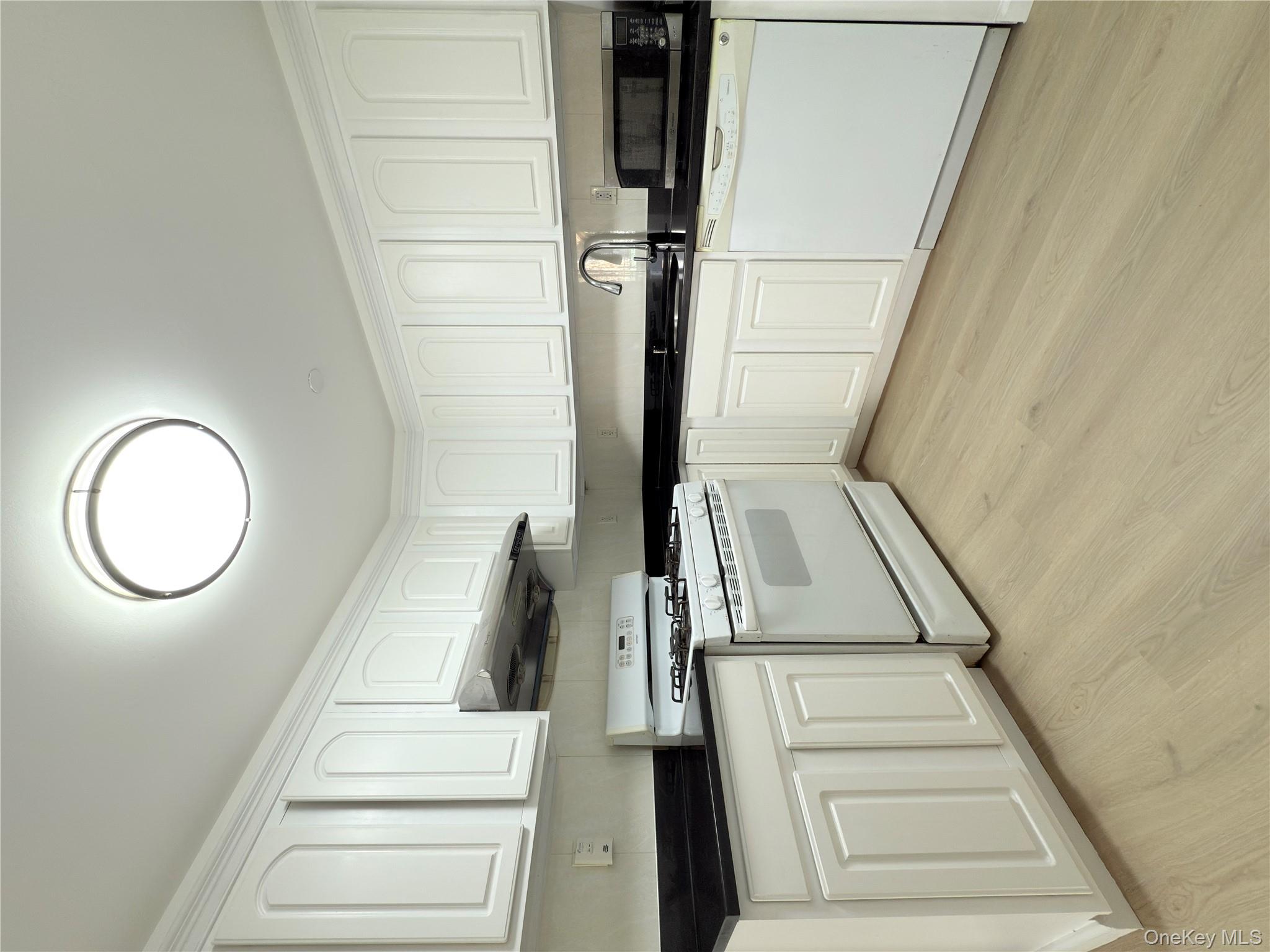 43-17 Union Street, Unit 8B Queens, NY 11355 - Photo 12 of 16 Kitchen featuring stove, white cabinets, dishwashing machine, and light wood-style floors
