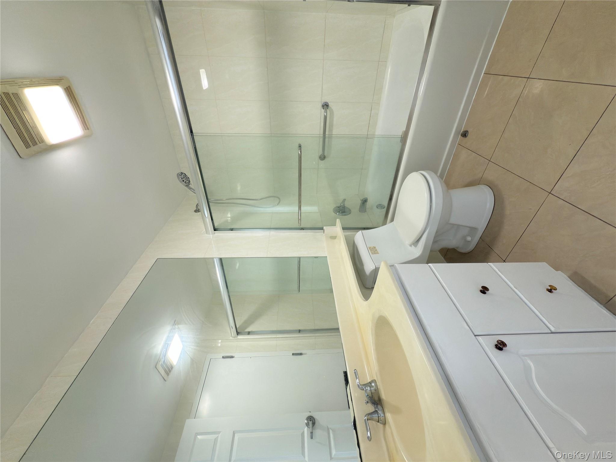 43-17 Union Street, Unit 8B Queens, NY 11355 - Photo 9 of 16 Full bathroom with light tile patterned flooring, vanity, and enclosed tub / shower combo