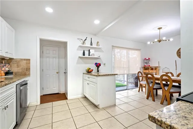 a kitchen with granite countertop white cabinets stainless steel appliances and a sink